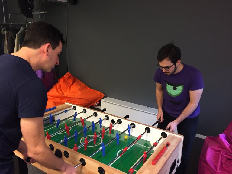 Two men playing Table Football in an office room